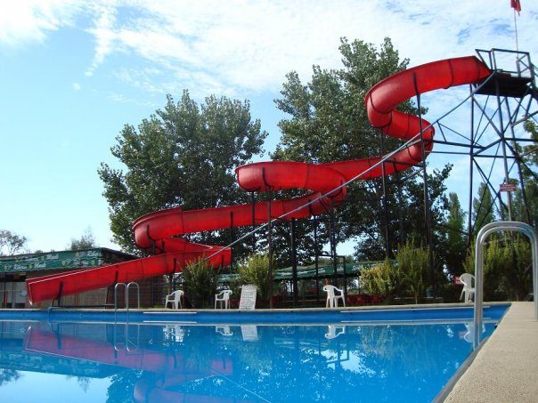 Tobogán rojo en espiral sobre la piscina